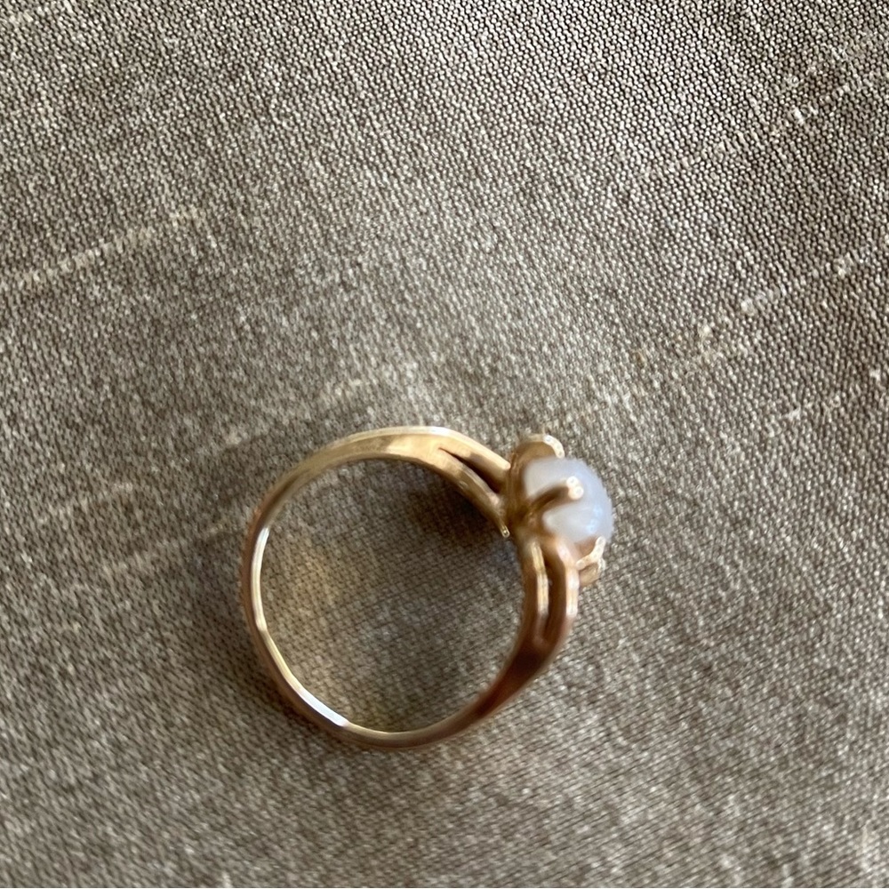 14K gold ring.  4.46 grams.  Not sure what stone? Maybe white Star Sapphire??